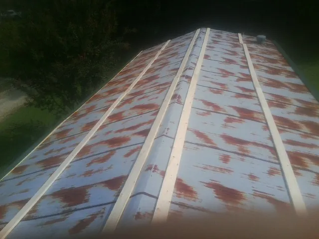 Rusted metal roof panels with new wood purlins before replacement — Storm Damage Roof Repair in Bussey by Roofing Brothers
